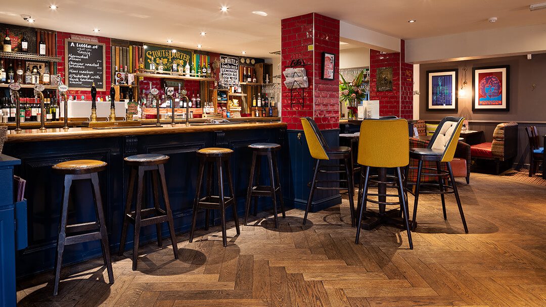 A view across the bar area in a Barons pub showing the bar stools lined up.