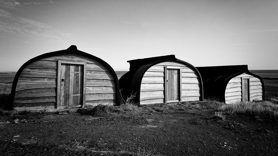 A group of huts formed form upturned fishing boats in Black and White. Located on Holy Island.
