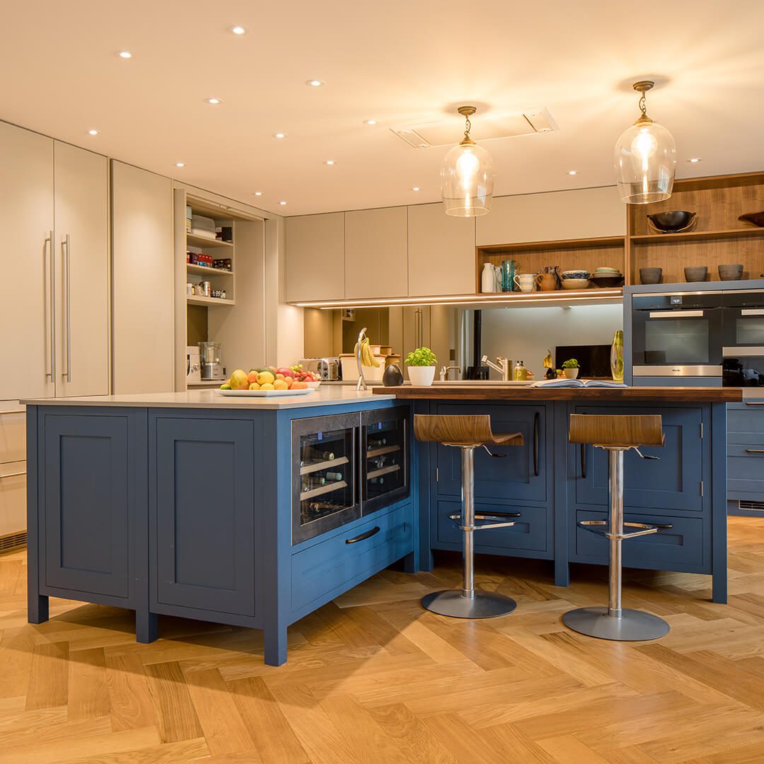 Ambient image of shaker style kitchen in royal blue featuring a kitchen island and integrated wine cooler