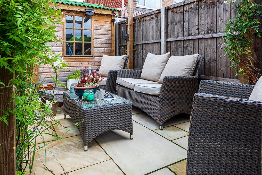 A cosy corner in a garden design which features a private area with rattan seating